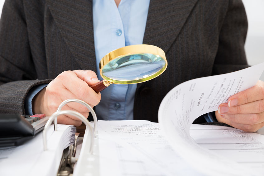 IRS agent examining Pasadena Business Tax Return with a magnifying glass